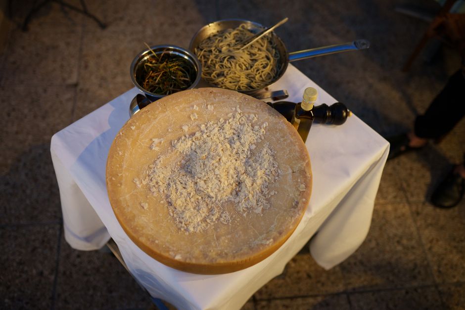 A beautifully arranged pasta station featuring a parmesan cheese wheel, fresh pasta, and herbs.